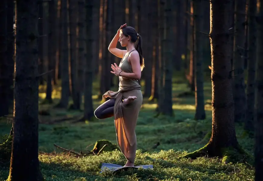 Frau macht die Yogaübung der Baum im Schwarzwald