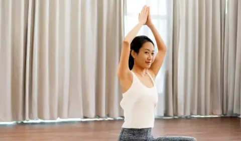 Frau macht Yogaübungen gegen Stress