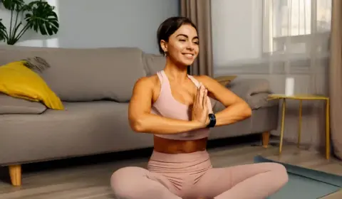 Frau macht Yogaübungen im Wohnzimmer