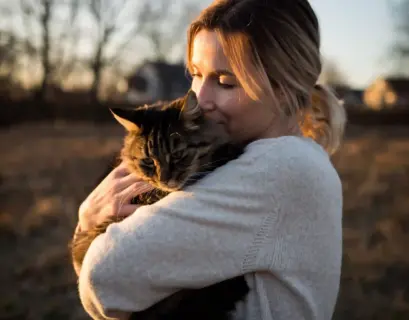 Frau kuschelt mit Katze auf dem Arm