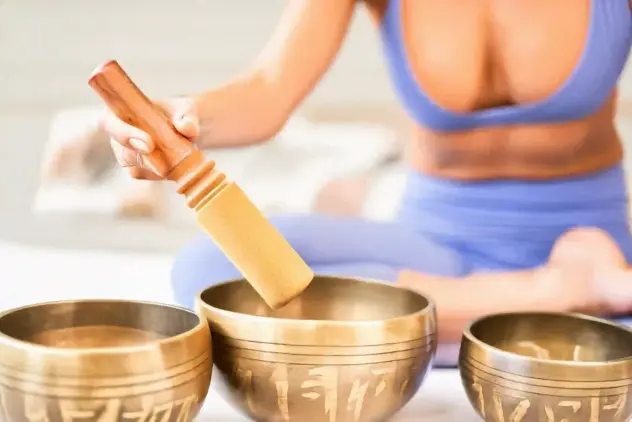 Klangschalen mit einer Frau im Hintergrund