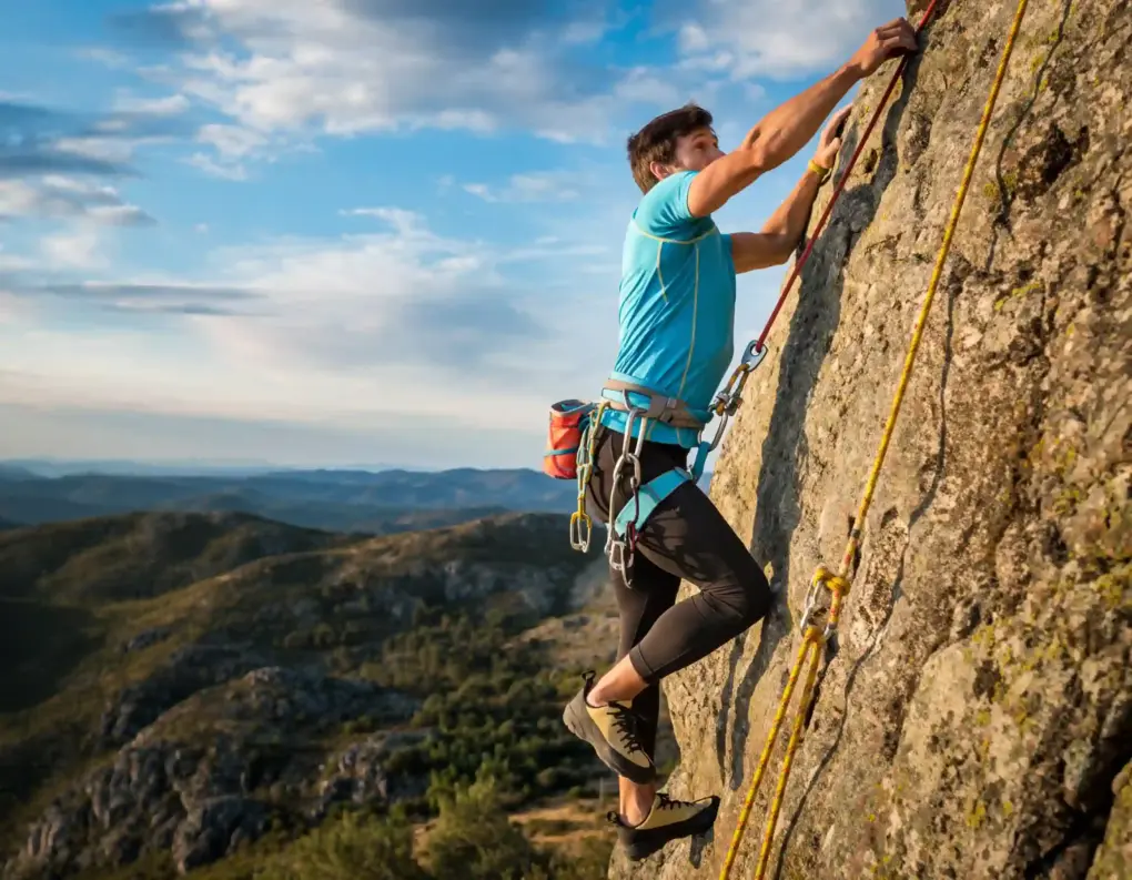 Mann klettert in Portugal an einer Felswand