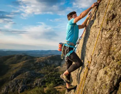 Mann klettert in Portugal an einer Felswand