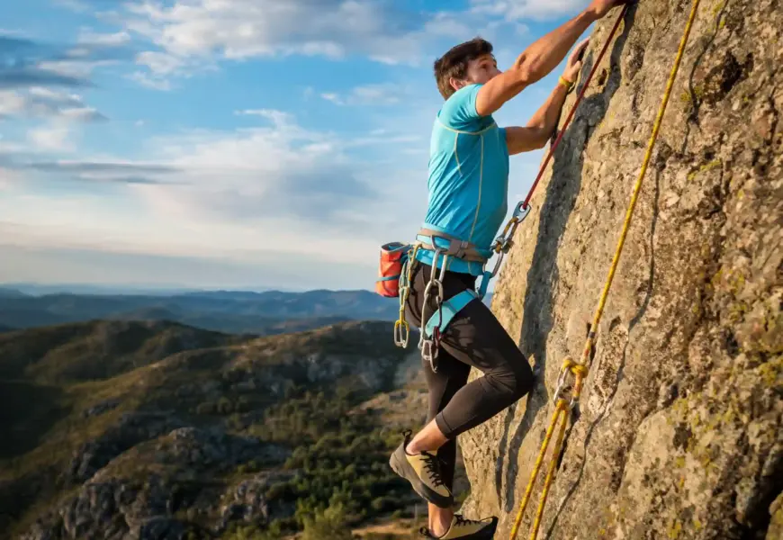 Mann klettert in Portugal an einer Felswand