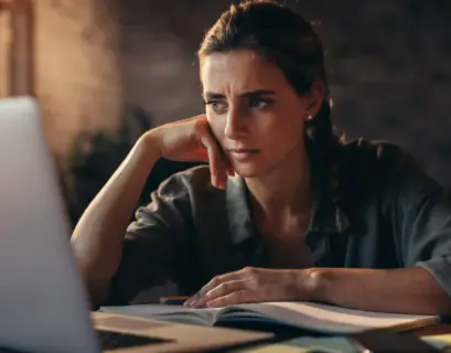 Frau sitzt vor dem Laptop und Prüfungsstress