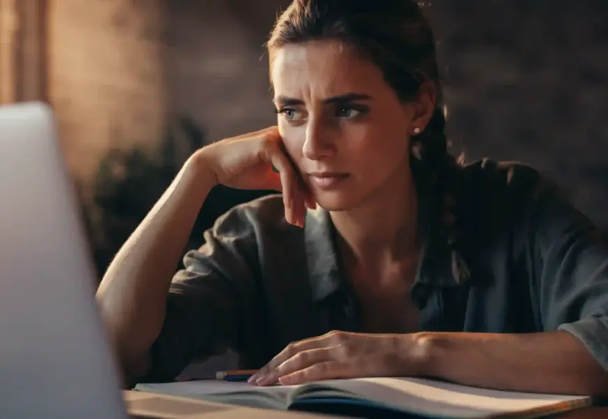 Frau sitzt vor dem Laptop und Prüfungsstress