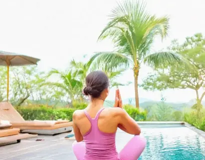 Frau macht yoga neben einem Pool im Garten