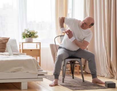 Mann macht Yoga auf seinem Stuhl zuhause