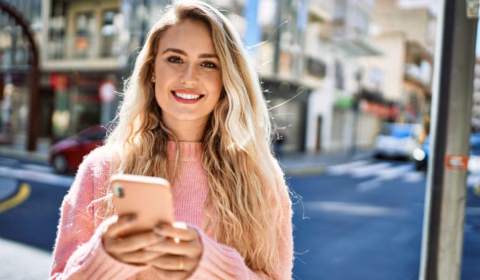 Frau hält ihr Handy und schreibt mit der Psychologin von der Pinga App