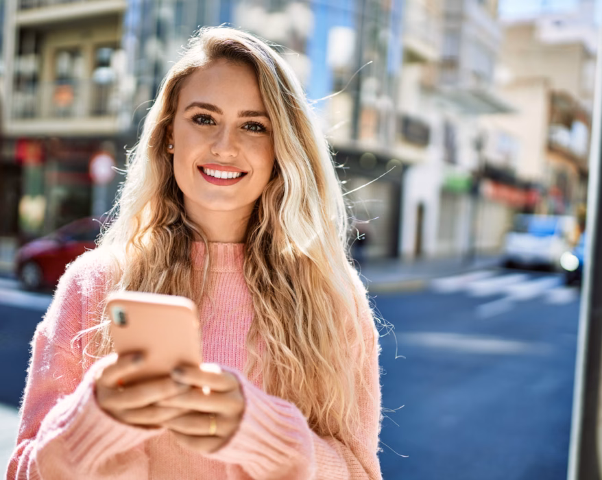 Frau hält ihr Handy und schreibt mit der Psychologin von der Pinga App
