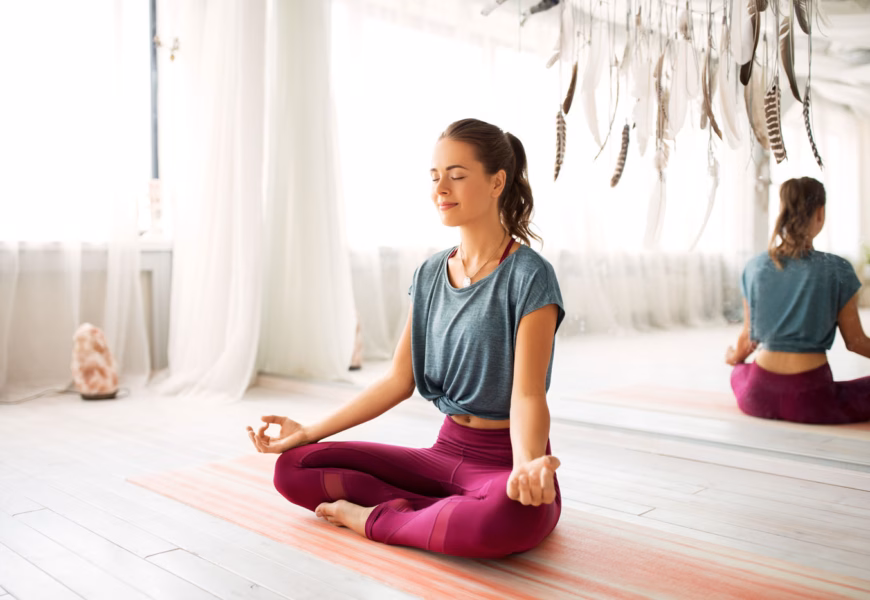Frau sitzt im Meditationssitz auf dem Boden und meditiert