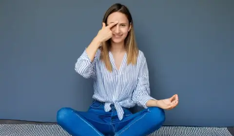 Frau hält sich das dritte Auge