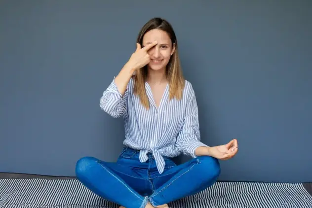 Frau hält sich das dritte Auge