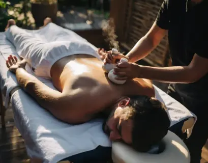 Mann bekommt eine Rückenmassage mit Kräuterstempeln