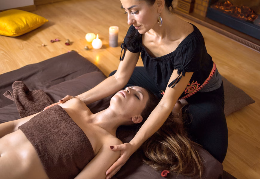 Tantra Expertin hält eine junge, liegende Frau an den Schultern