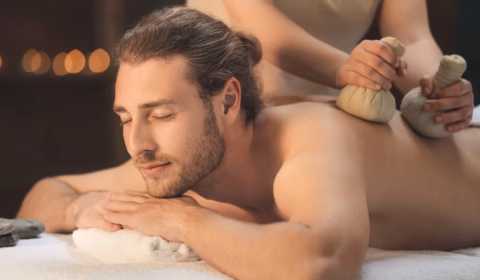 Mann bekommt eine Kräuterstempel Massage in seiner Kur für Männer