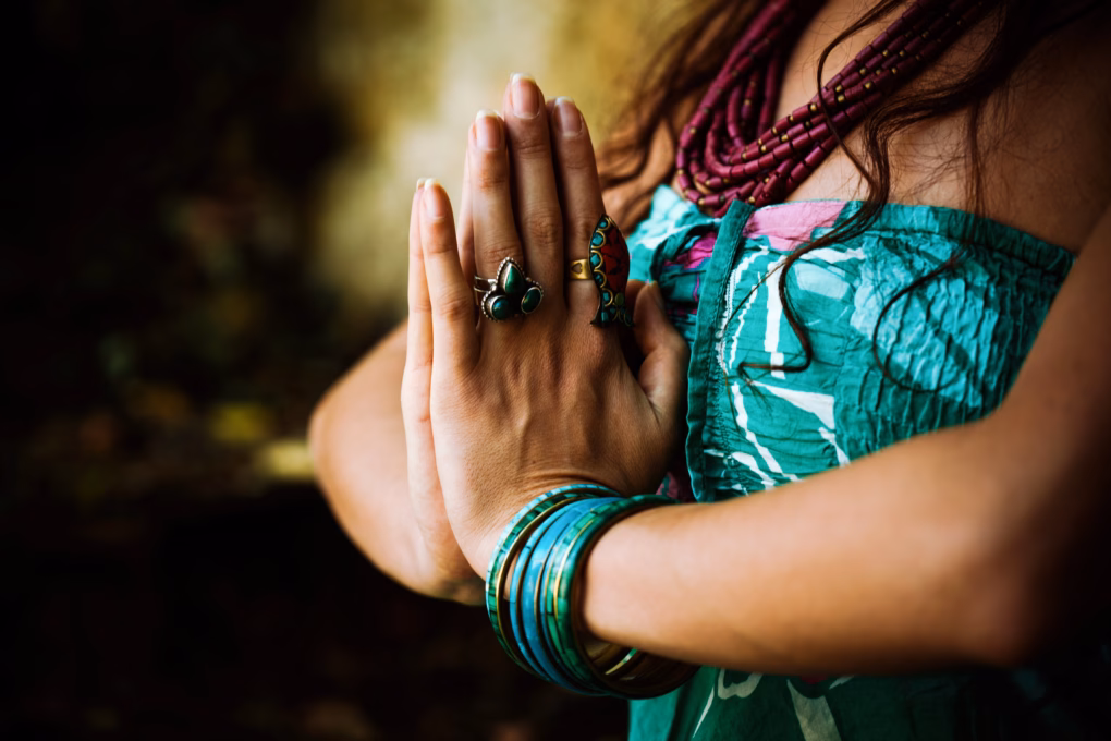 Frau hält die Hände vor der Brust in der Namaste Haltung