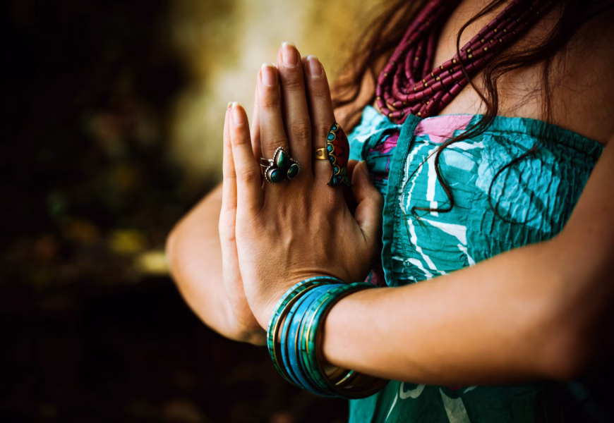 Frau hält die Hände vor der Brust in der Namaste Haltung