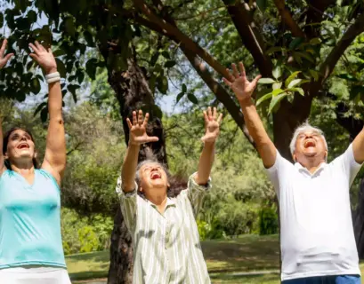 Drei Leute machen in der Natur Lachyoga