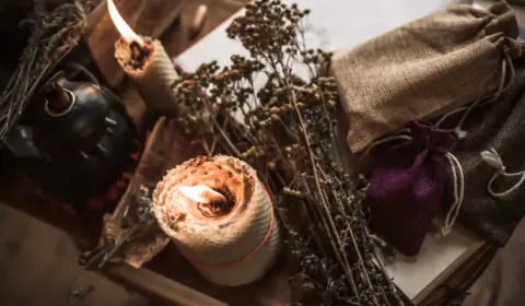 Magisches Attribut auf einem Tisch, Spirtuelles-Konzept, Kerzenflamme und andere Rituale