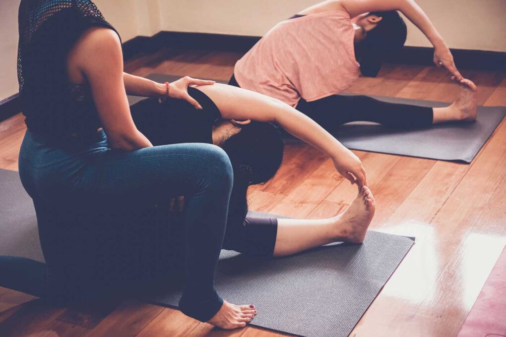 Yogalehrerin macht Sivananda Yoga mit ihren Schülern