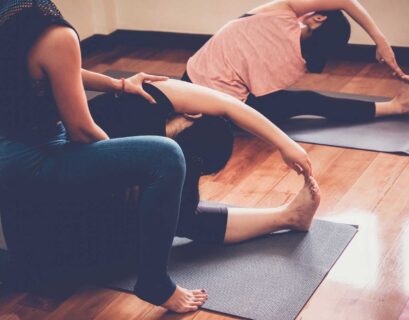 Yogalehrerin macht Sivananda Yoga mit ihren Schülern