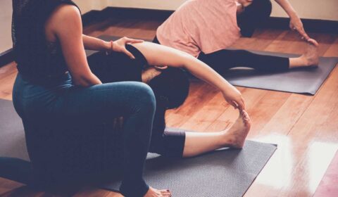Yogalehrerin macht Sivananda Yoga mit ihren Schülern