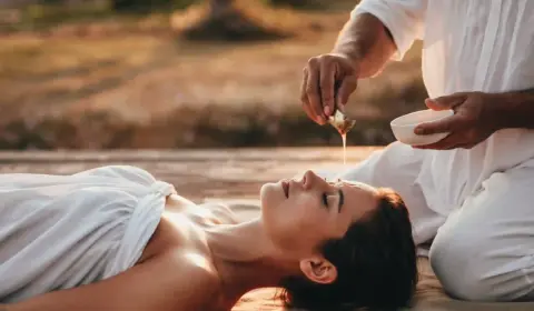 Frau bekommt einen ayurvedischen Ölstirnguss