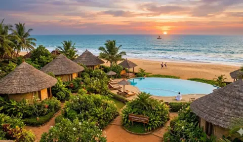 Soma Manaltheeram Ayurveda Beach Village in Kerala, Indien: Traditionelle Cottages mit Reetdächern, Pool und Blick auf den Indischen Ozean bei Sonnenuntergang.